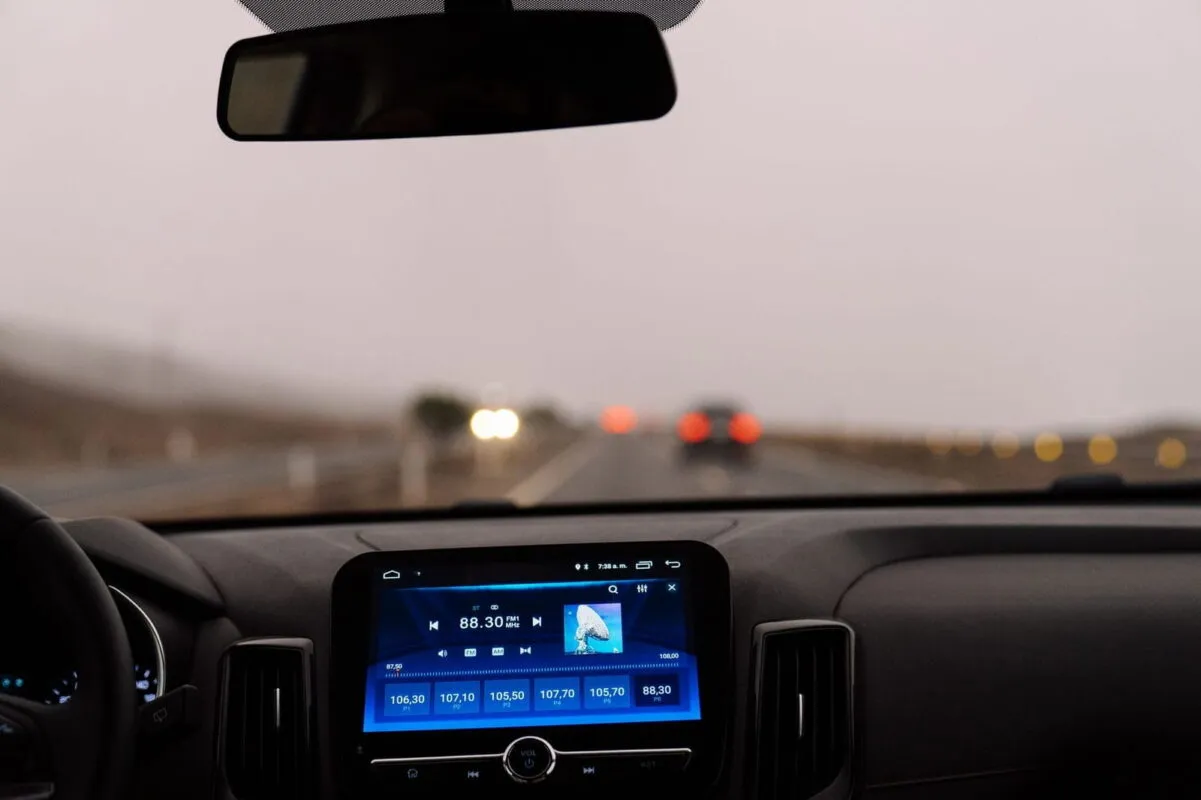רמקול Bluetooth מותקן על לוח המחוונים של רכב במהלך נהיגה ביום